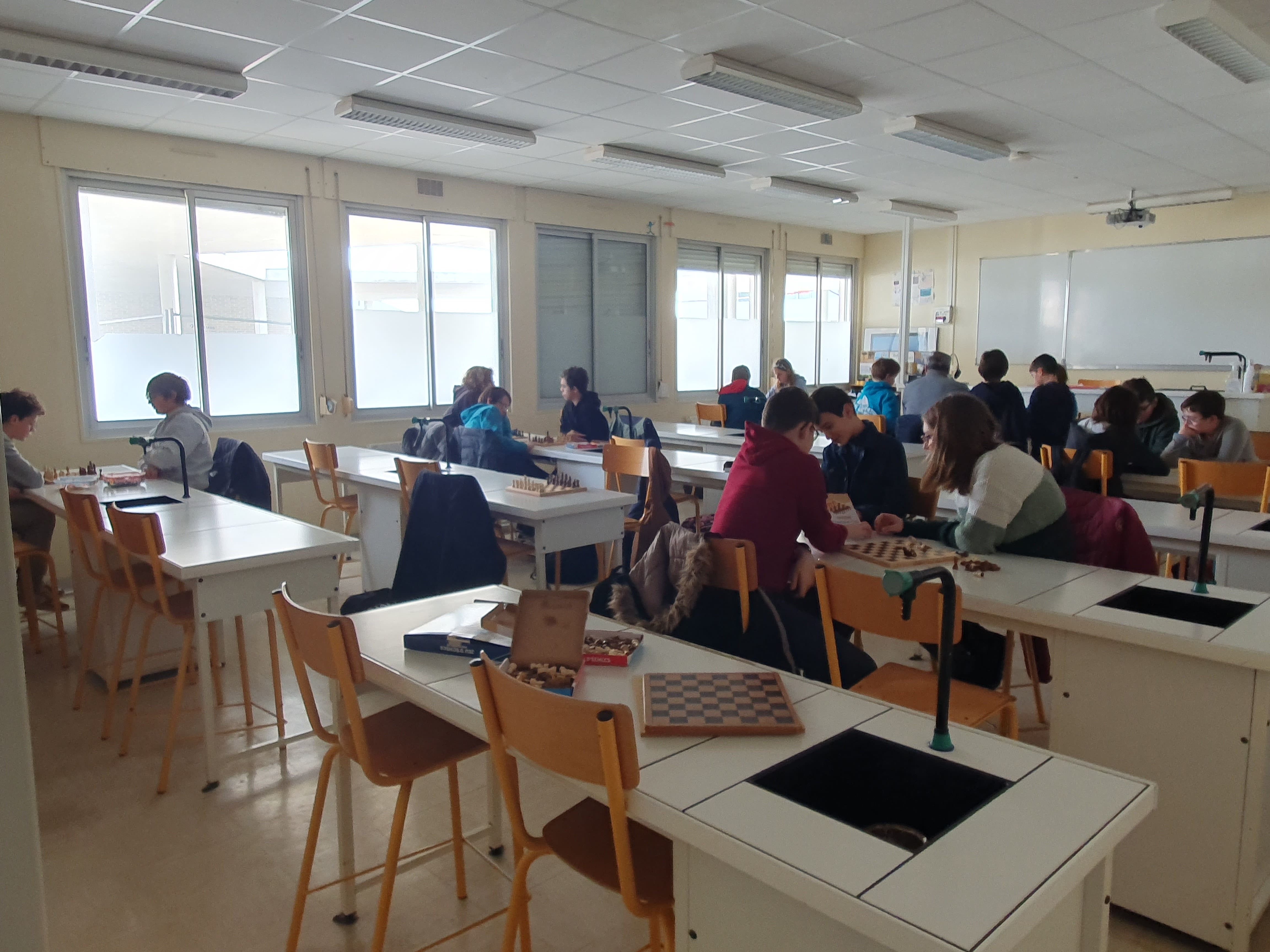 Photo d'élèves assis dans une salle en train de jouer aux échecs
