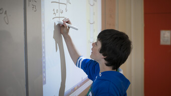 Elève au tableau faisant un exercice de maths