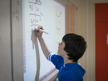 Elève au tableau faisant un exercice de maths