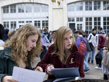 Deux élèves travaillent dans la cour du collège